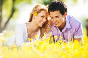 Beautiful couple lying among the dandelions.